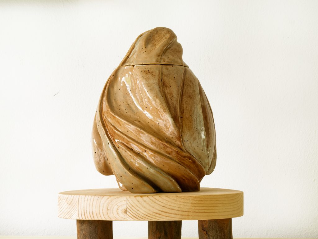 Handgemaakte keramieken urn met uniek design en persoonlijke afwerking.
